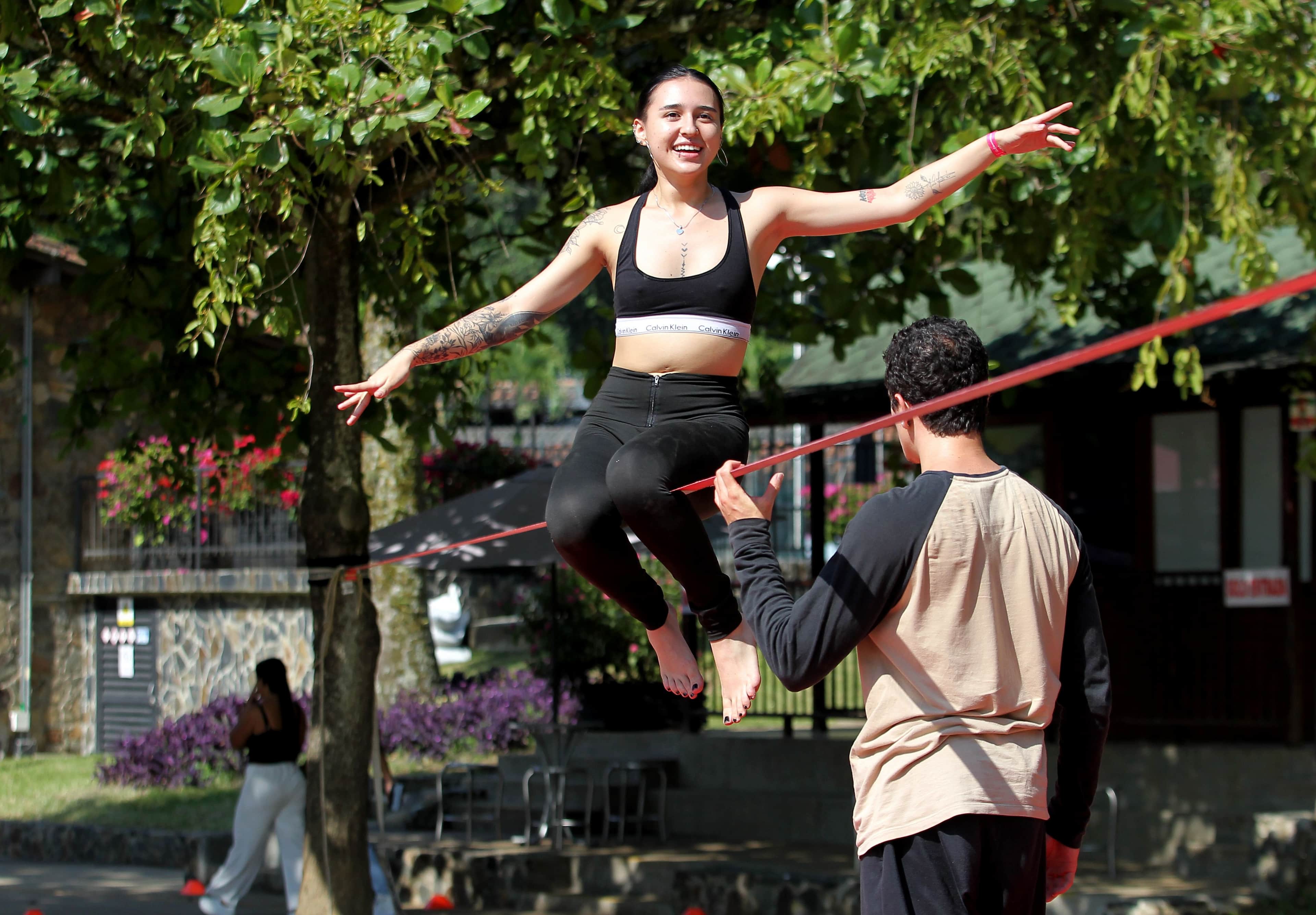 Fotografía de mujer practicando equilibro sobre una cuerda floja