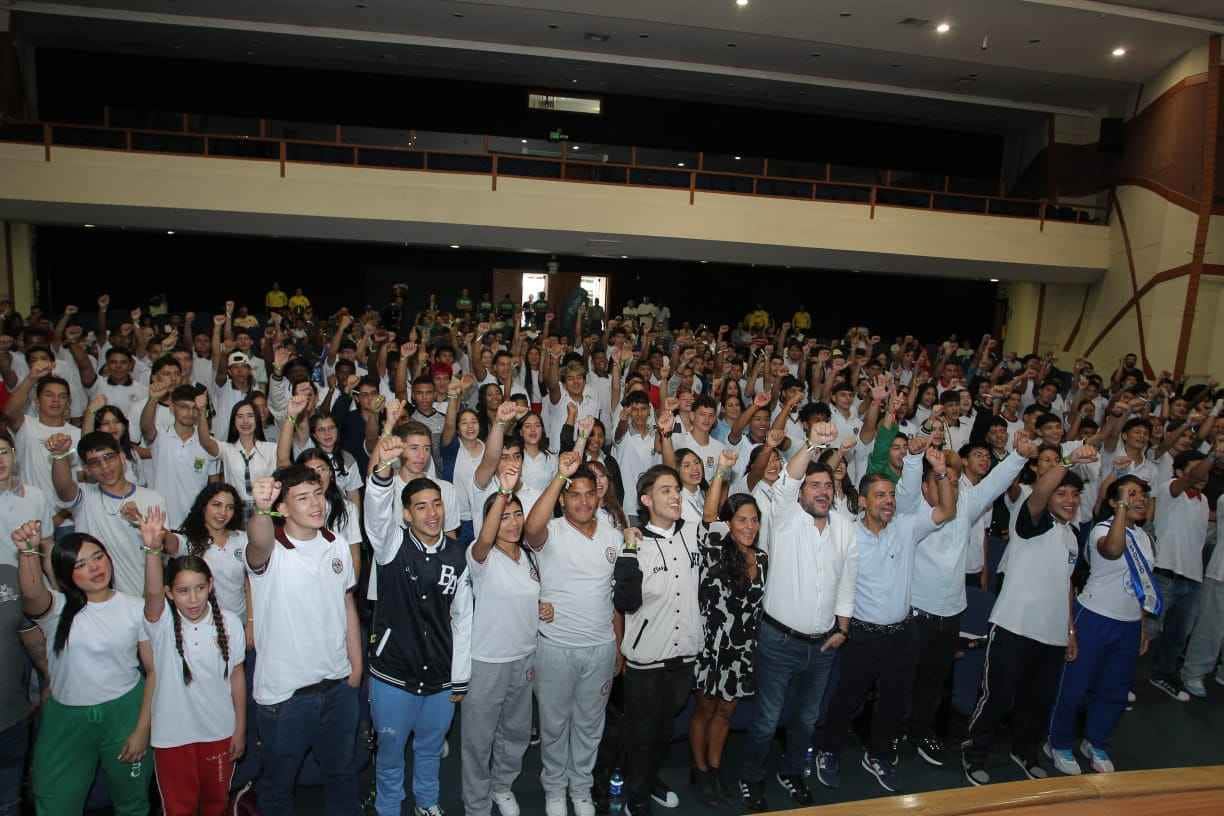 Estudiantes de una institución educativa de pie en un auditorio 
